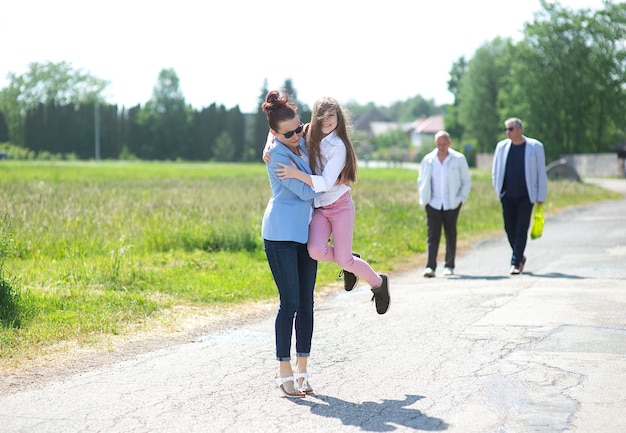 Photo yong mother and child daughter girl teen having fun walking on city sidewalk