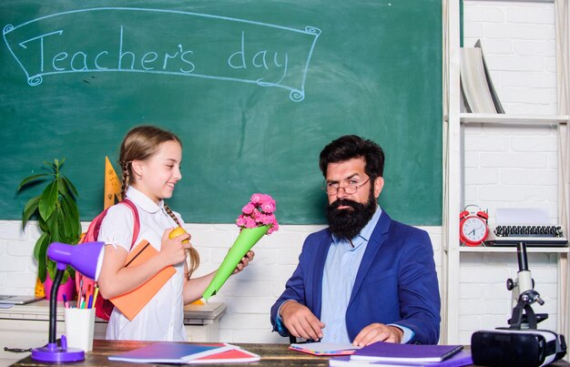 あなたは最高の先生の日のための最高の花のプレゼントです9月1日は学校に戻ります幸せな先生の日花の先生の日を持つ小さな女子高生の子供Daugghterと花の父