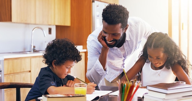 You both doing a great job keep going Cropped shot of a young father helping his adorable son and daughter with their schoolwork at home