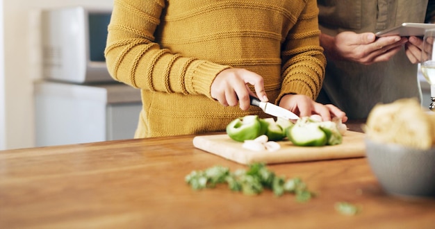 写真 自宅で食事を準備しているときにデジタルタブレットを使用してカップルの自家製の食事を切り取ったショットを打ち負かすことはできません