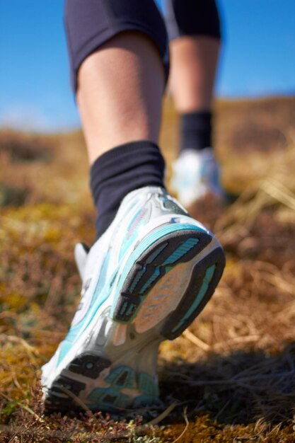 You dont have to go fast you just have to go A cropped shot of a womans running shoe as she is running on a nature trail