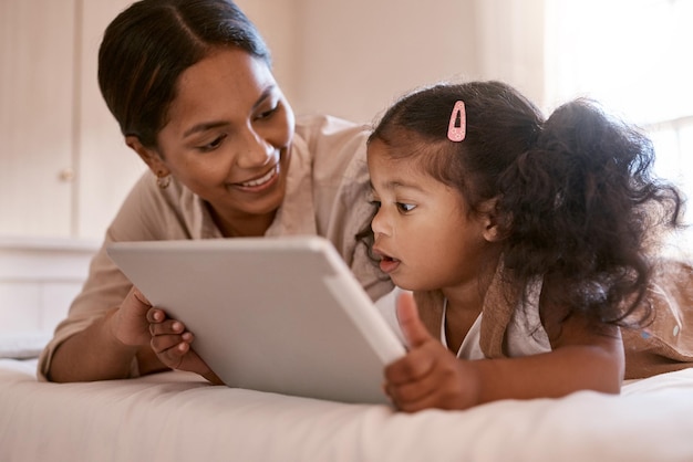 Do you like it Shot of a little girl using a digital tablet with her mother at home