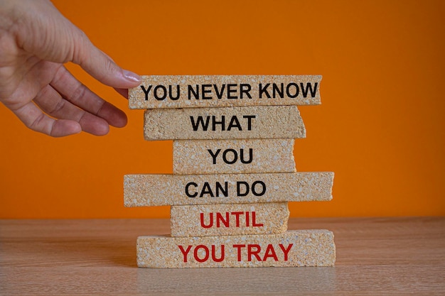 You never know what you can do until you try Red words on brick blocks Beautiful wooden table