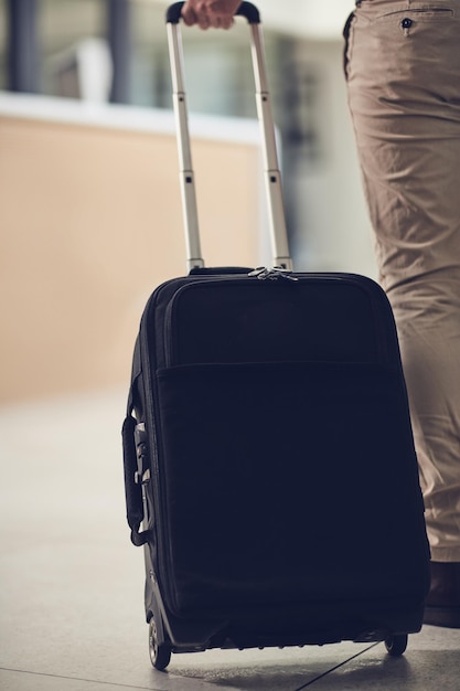 Photo you never know where life will take you rearview shot of an unrecognizable man carrying his luggage in an airport