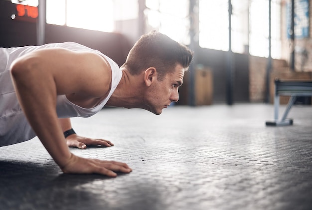 Photo you were built to be the best shot of a young man doing pushups in a gym