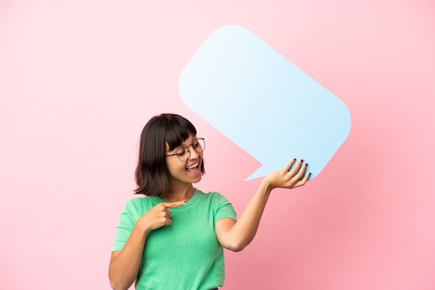 Photo youing woman holding an empty speech bubble and pointing it