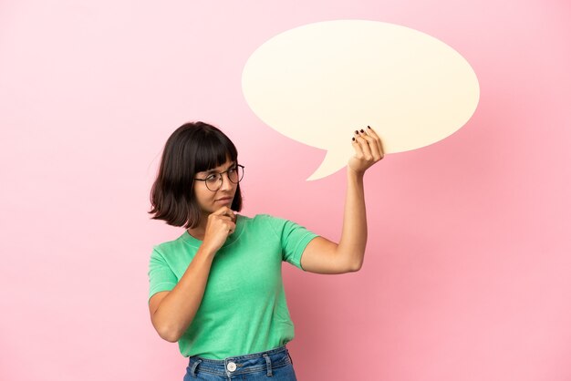 Youing woman holding an empty speech bubble and thinking