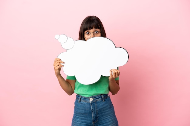 Youing woman holding a thinking speech bubble and hiding behind it