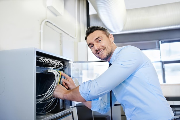 Youll be online in one more minute Portrait of a smiling computer engineer working on a server