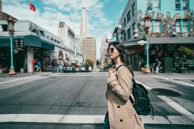 Photo youn asian female model walking across the road and wearing fashionable and stylish.