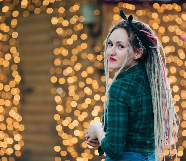 Youn informal woman with dreadlocks hairstyle and plaid shirt