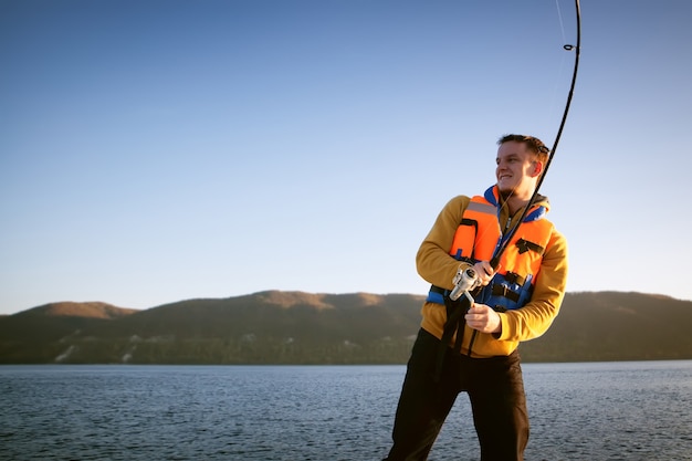 Youn man vissen vanaf een boot