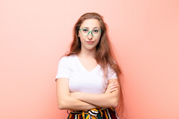 Youndブロンドの女性は不機嫌でがっかりしている、深刻な顔つき、イライラして腕を組んで怒っている