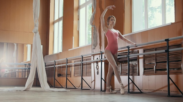 Young acrobatic girl shows the flexibility of the body at the ballet bar, circus artist