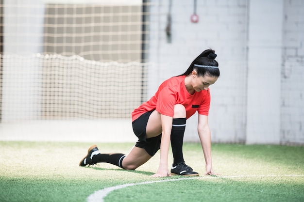 사진 경기 전에 필드에서 스트레칭 운동을 하 고 스포츠 유니폼에 젊은 활성 여성 축구 선수