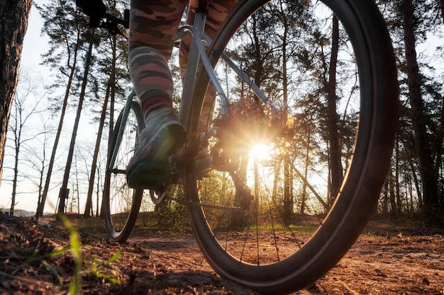 Young active girl riding bicycle on dirt path in the forest Selective focus