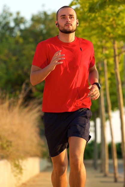 Young active man jogging outdoors 