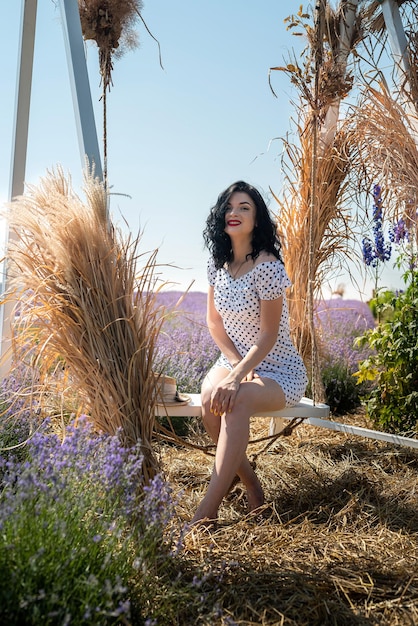 Young and active woman in summer dress posing on swing