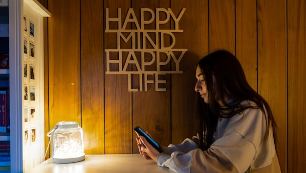 Foto young adolescent girl concentreerde zich 's avonds met het lezen van een elektronisch boek met haar ereader