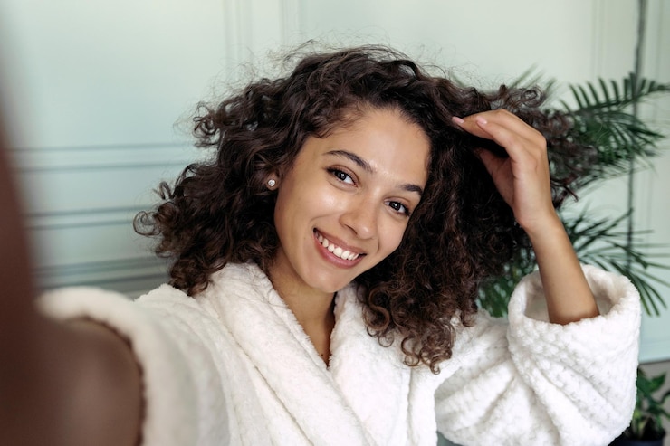 Young adult afro american woman in bathrobe making self portrait