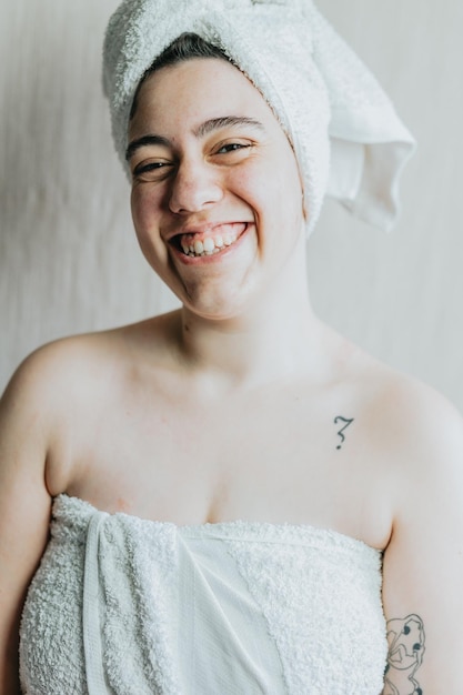 Young adult after taking a shower big smiley face Woman wrapping her body with white towel and drying hair to wipe her hair after being relaxed in a bath Portrait in white background