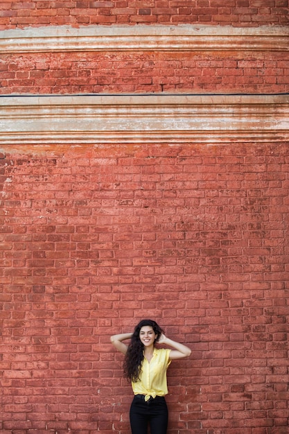 Photo young adult beautiful brunette girl in casual clothes on the background of a building