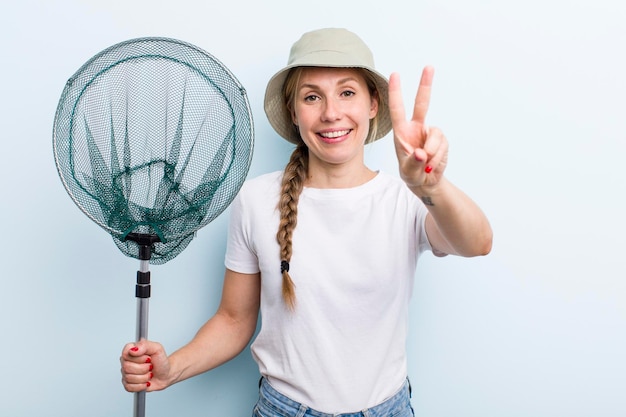 Young adult blonde fisher woman with a net holidays and hobbie concept