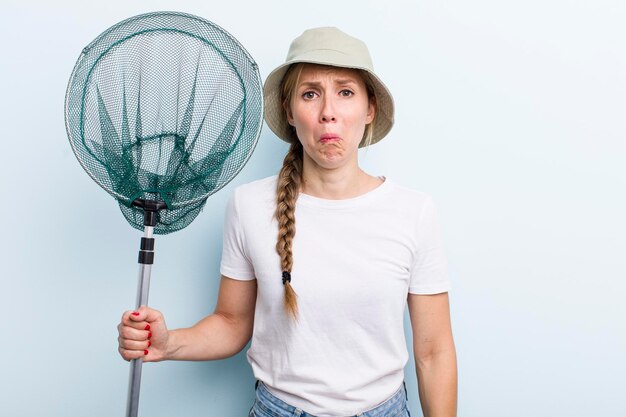 Young adult blonde fisher woman with a net holidays and hobbie concept