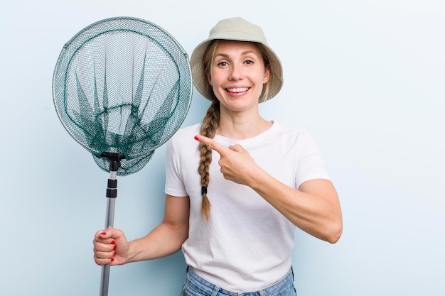 Young adult blonde woman fisher with a net and summer concept