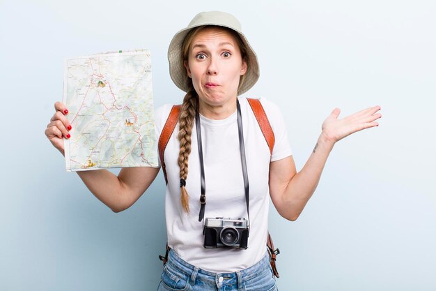 Young adult blonde woman tourist with a map holidays concept