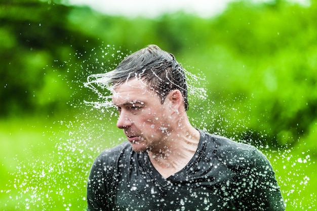 Photo young adult completely drenched shaking his head