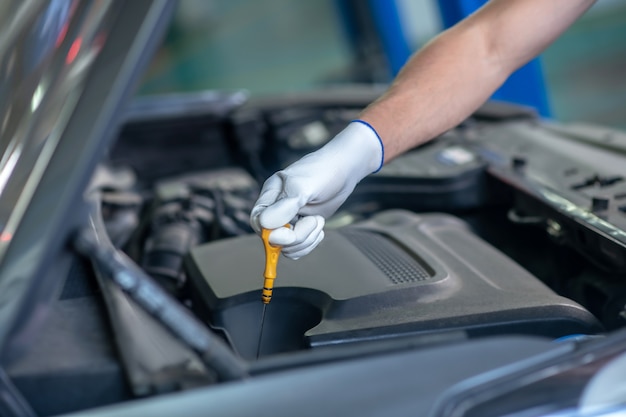 Young adult confident man in work uniform working on cars