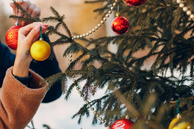 Young adult couple decorates christmas tree in winter forest New year pine holiday party celebration concept