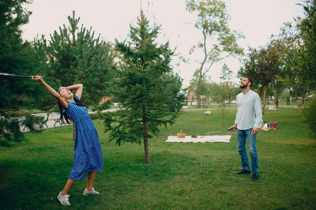 Young adult couple playing badminton in the park