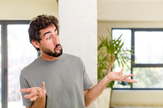 Young adult crazy man with expressive pose at a modern house interior