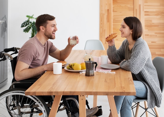 Photo young adult eating with disabled friend