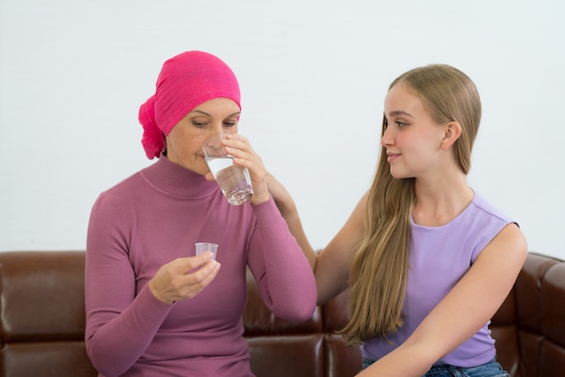 Young adult female cancer patient spending time with her daughter at home.