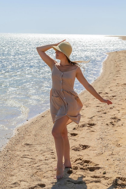 Молодая взрослая женщина наслаждается отдыхом на морских прогулках вдоль побережья океана в роскошном курорте, глядя на голубую чистую воду