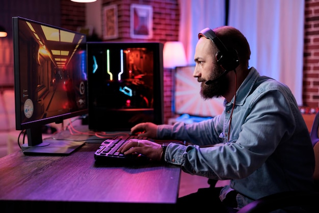 Молодой взрослый сосредотачивается на чемпионате по онлайн-видеоиграм, играет в экшн-игру в прямом эфире. Кавказский игрок развлекается с виртуальным киберспортивным турниром на компьютере.