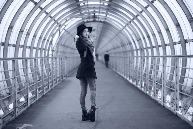 Young adult girl in the architectural tunnel of the bridge