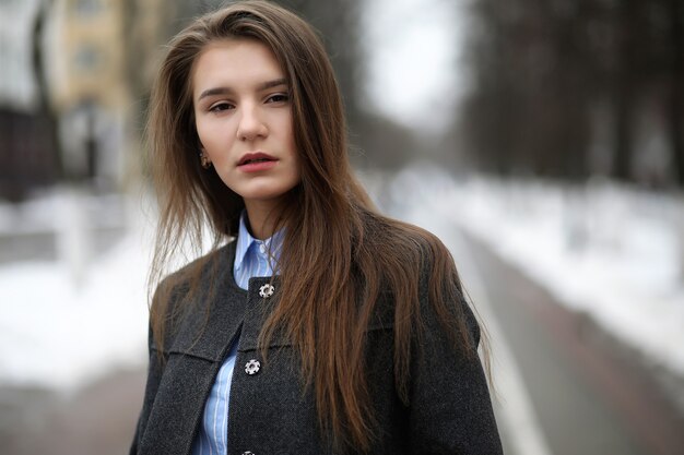 Young adult girl in coat on the street in the city