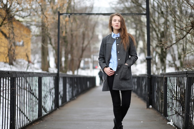 Young adult girl in coat on the street in the city