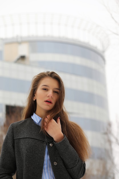 도시의 거리에서 코트를 입은 젊은 성인 소녀