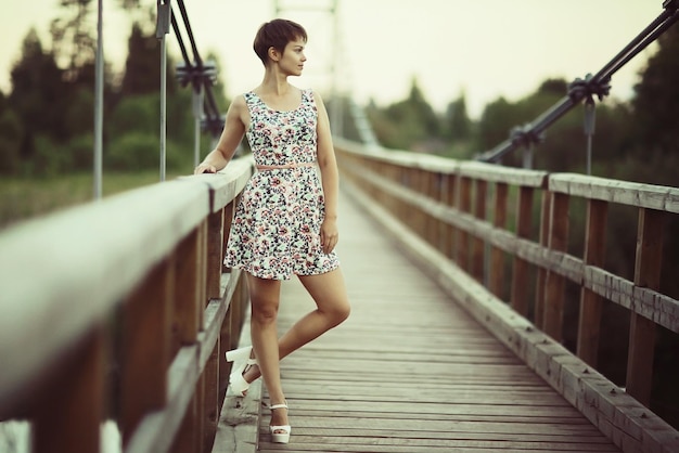 Young adult girl in a short summer dress in a rustic style