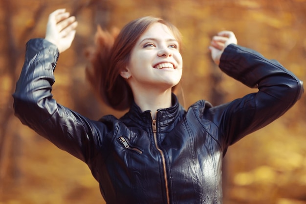 Young adult girl on a walk in the park jacket clothes