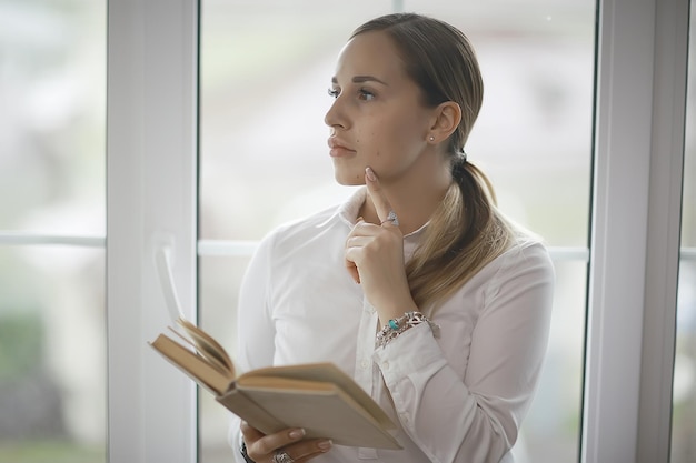 本の学習、読書、ビジネスを持つ若い大人の女の子