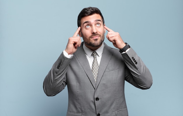 Young adult handsome businessman feeling confused or doubting, concentrating on an idea, thinking hard, looking to copy space on side