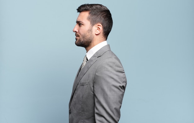 Young adult handsome businessman on profile view looking to copy space