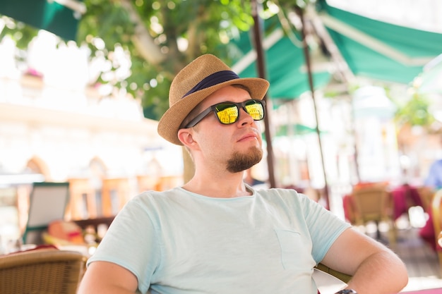 Young adult handsome man sitting at cafe or street restaurant.