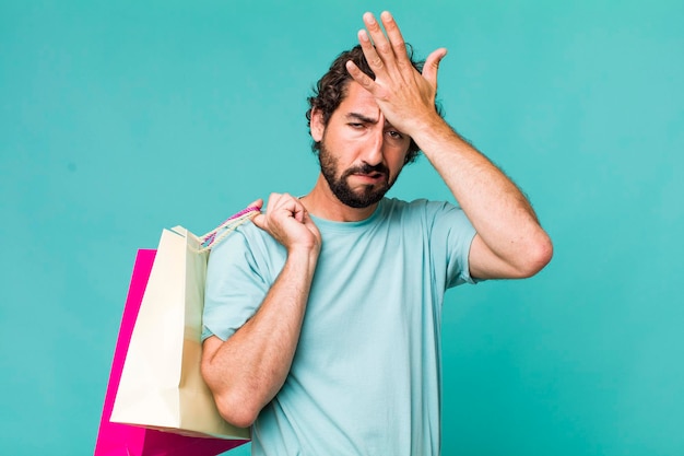 Photo young adult hispanic crazy man shopping bags concept